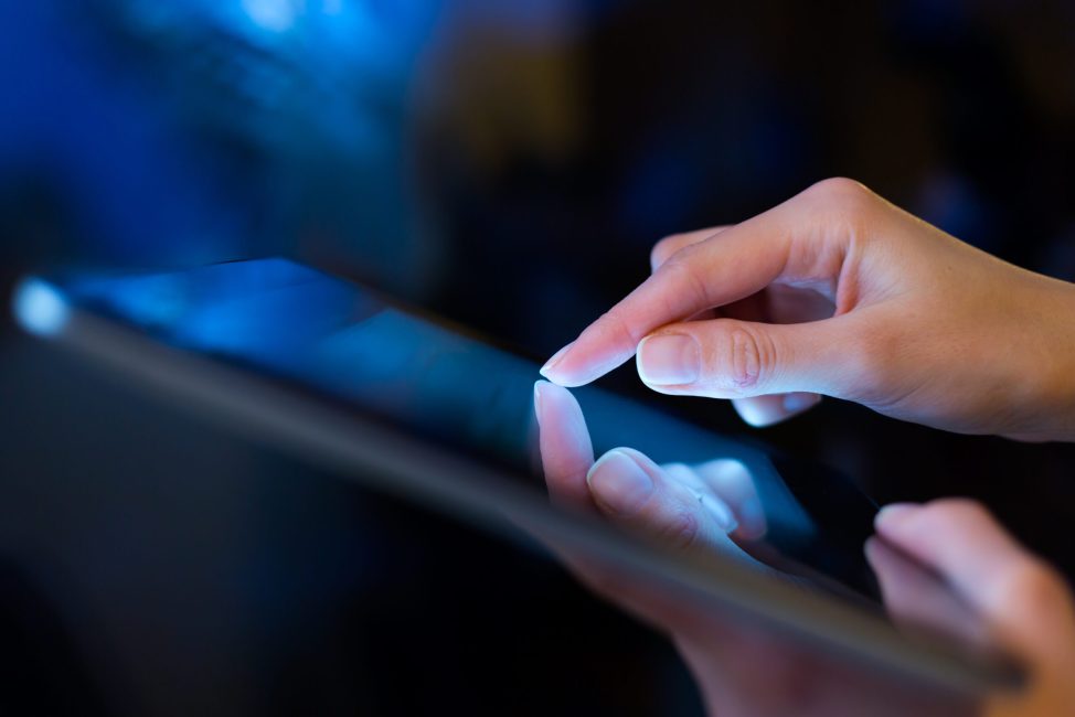 hand presses on screen digital tablet
